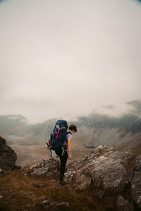 Rear view of friends on mountain against sky