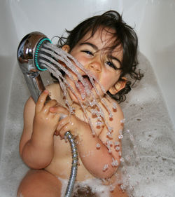 Portrait of girl enjoying bath in tub