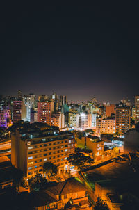 Illuminated cityscape against sky at night