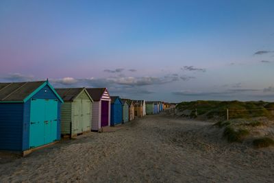 Scenic view of beach against sky at sunset