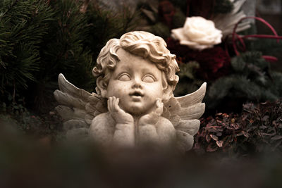 Close-up of angel statue against plants