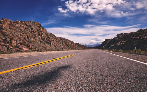 Road by mountain against sky