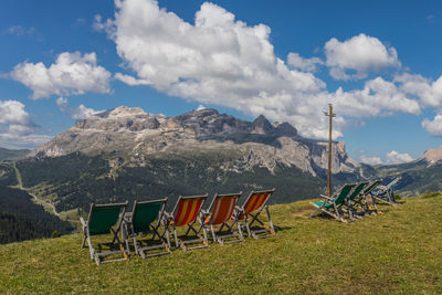 Chairs arranged on mountain against sky
