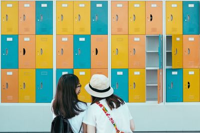 Rear view of two people in corridor