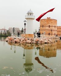 Reflection of lighthouse in puddle