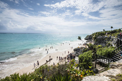 People at beach against sky