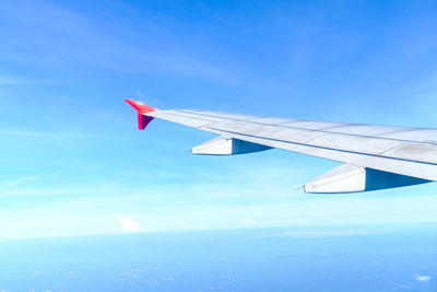 Close-up of airplane wing against blue sky