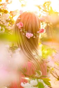 Close-up of woman with pink flowers blooming outdoors