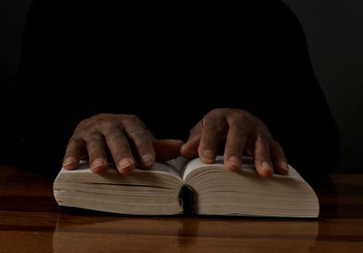 Midsection of man holding model house on table