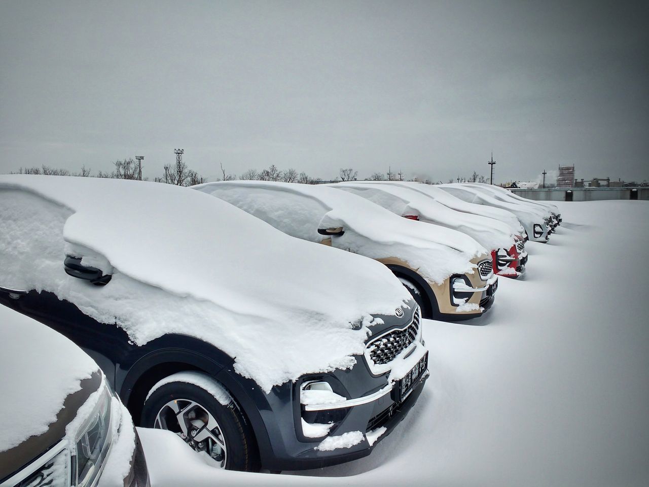 VEHICLES ON ROAD AGAINST SNOW COVERED SKY