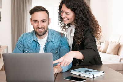 Portrait of a smiling young woman using phone