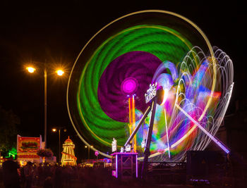 Low angle view of illuminated ferris wheel against sky at night