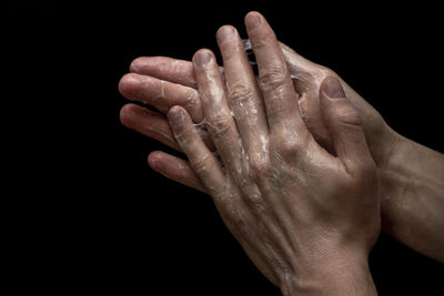 Close-up of person hand against black background