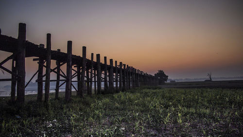 Built structure on field against clear sky during sunset