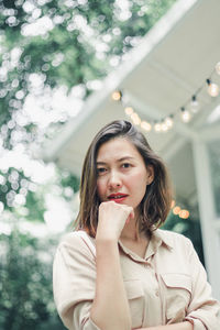 Low angle portrait of beautiful woman standing outdoors