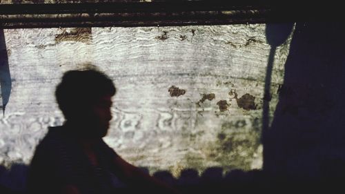 Rear view of silhouette man standing against wall