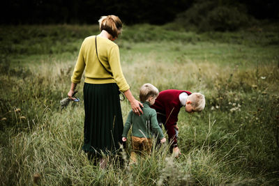 A trio of family walking from behind in the forest