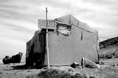 Low angle view of text on old building against sky