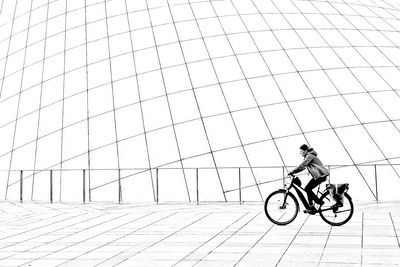 Side view of man riding bicycle on city