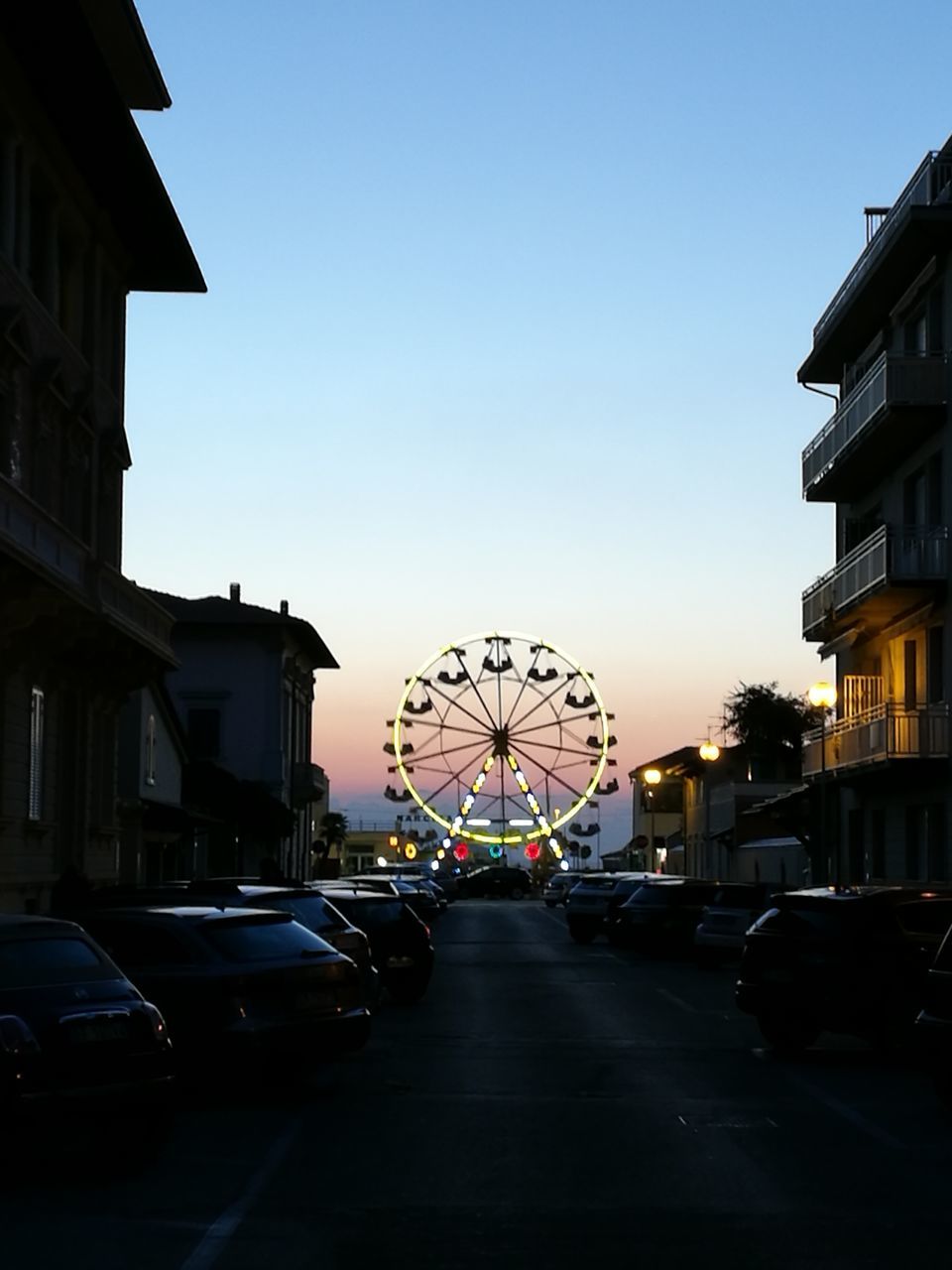 CARS ON CITY STREET AGAINST CLEAR SKY DURING SUNSET