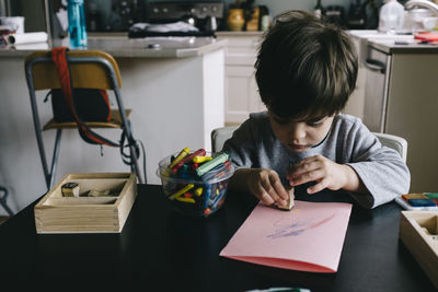 Boy playing with rubber stamp at home