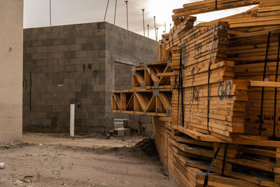 Stack of logs against building