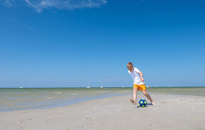 Full length of woman on beach against sky