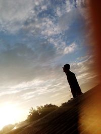 Silhouette man standing against sky during sunset