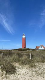 Lighthouse by sea against sky