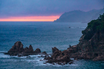 Scenic view of sea against sky during sunset.  the time is raining. and man shot a photo of the sea
