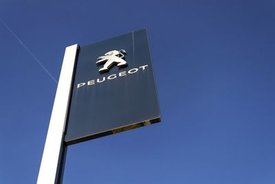 Low angle view of information sign against clear blue sky