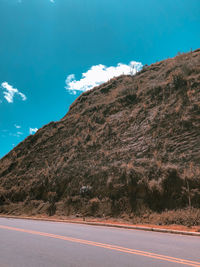 Road by mountain against blue sky