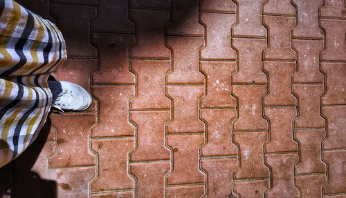 Low section of man standing on tiled floor