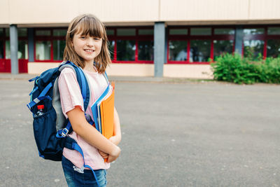 Portrait of a teenager schoolgirl in front of the school building. children begin the school year. 