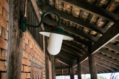 Low angle view of light bulb hanging on wall