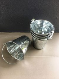 The bucket was placed on the floor beside the beautiful bright silver wall.
