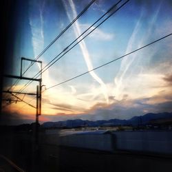 Electricity pylon against cloudy sky