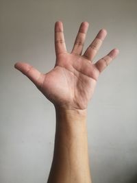 Close-up of human hand against gray background