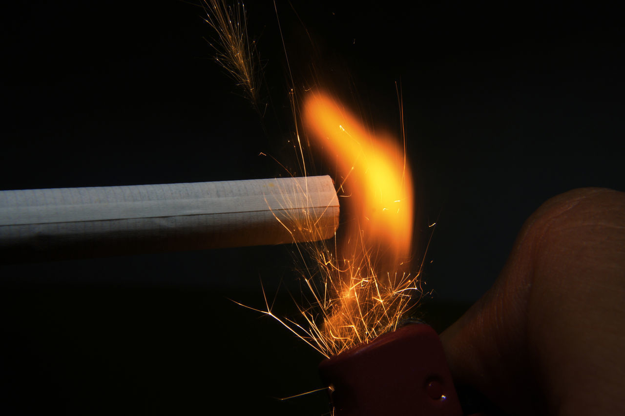 CLOSE-UP OF HAND HOLDING LIT UP