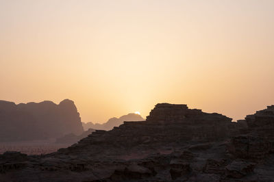 Rock formations against sky during sunset