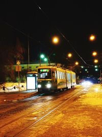 Train at railroad station against sky at night