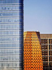 Low angle view of modern building against blue sky