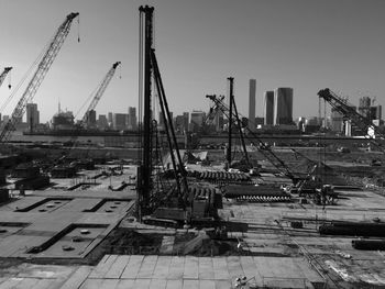 Buildings and crane against sky