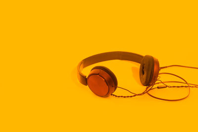 Close-up of headphones against yellow background