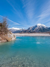 Scenic view of lake and mountains against blue sky