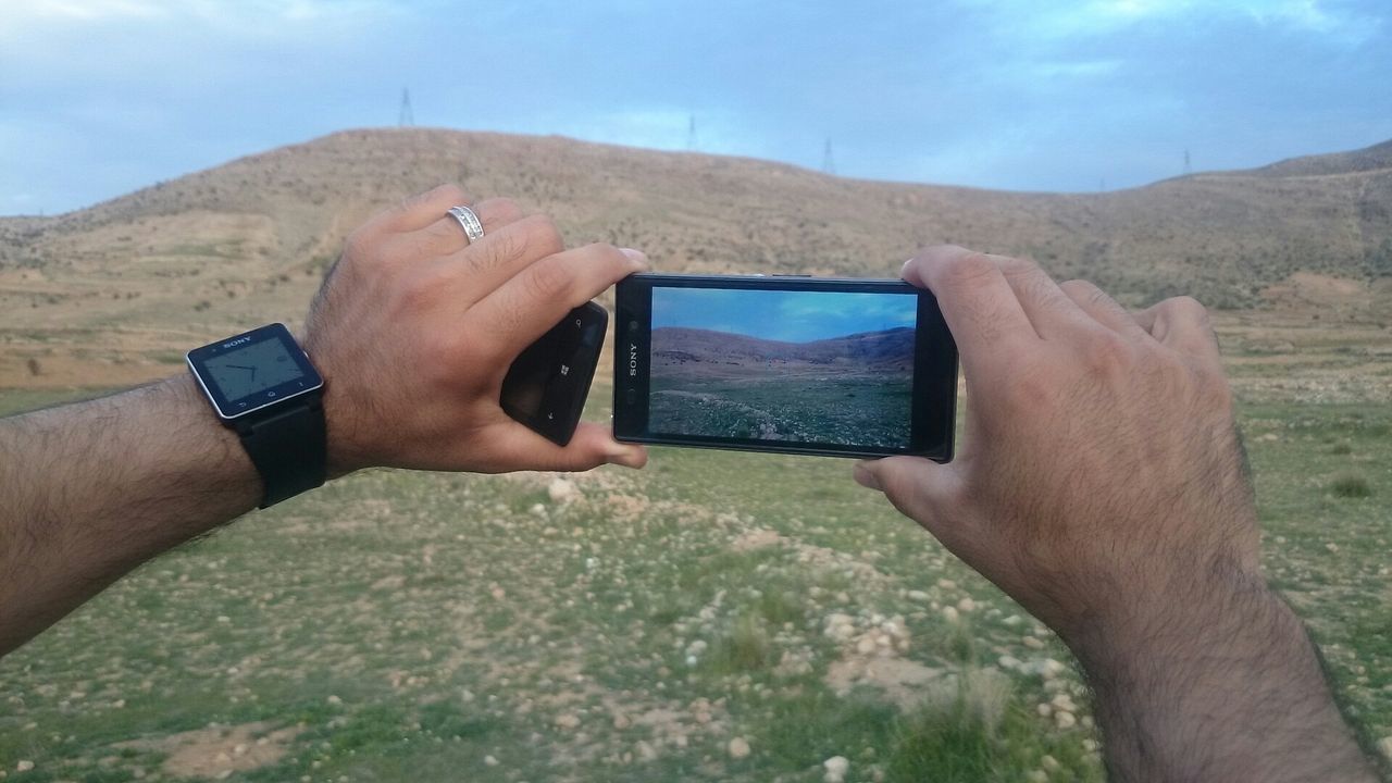 person, part of, holding, cropped, personal perspective, photography themes, technology, human finger, photographing, sky, smart phone, close-up, leisure activity, lifestyles, wireless technology, digital camera, mountain