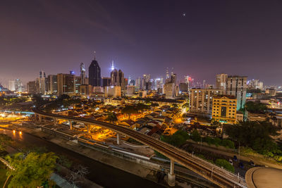 High angle view of illuminated buildings against sky at night