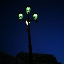 Low angle view of illuminated lights against clear blue sky