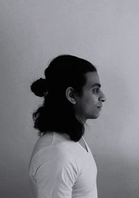 Profile view of young man standing by wall