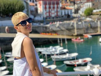 Mature woman wearing sunglasses while standing at harbor